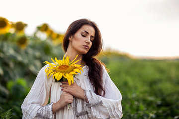 Woman in front of sunflower field at the end of day