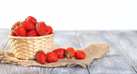 ripe strawberries in basket on wooden table. fresh sweet summer berries, harvest season