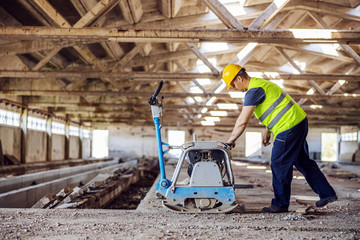 Fototapeta premium Full length of construction worker using machine.