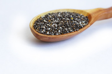 Black Chia seeds in a wooden spoon close-up. Macrophotography of Chia. Health food. Good nutrition. Nutritional Supplement.