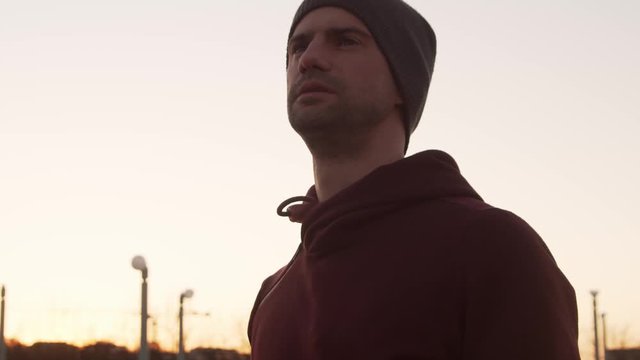 Young man having evening training outdoor. Urban sunset background. Fitness and sport.