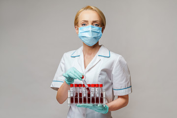 medical doctor nurse woman wearing protective mask and gloves - holding rack with virus blood tests