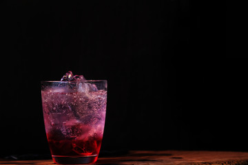 strawberry with sparkling water in glass on a wood background