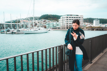 Woman using smartphone on Wellington waterfront