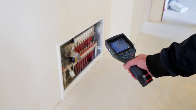 Close-up. Thermal imaging. The engineer checks the pipe with a thermal imager
