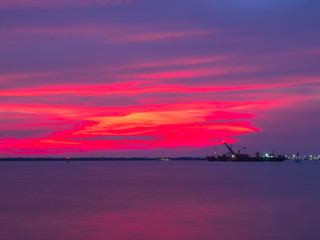 Fototapeta na wymiar A cargo ship is sailing in the Gulf of Thailand in the twilight hour.