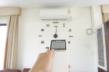blur image of  hand holding remote control aircondition for techology background.