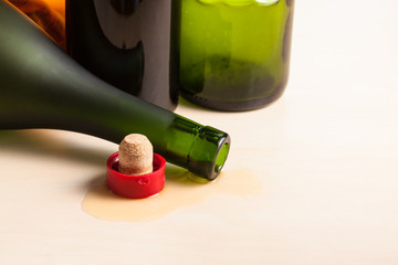 overturned bottle and cork near empty wine bottles