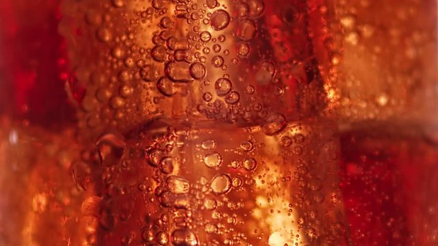 Macro shot raising up air bubbles at brown liquid iced cocktail. Shot on RED Raven 4k Cinema Camera
