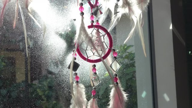 dream catcher hanging on window in the morning day