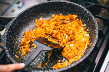 onion fried in a pan, orange color
