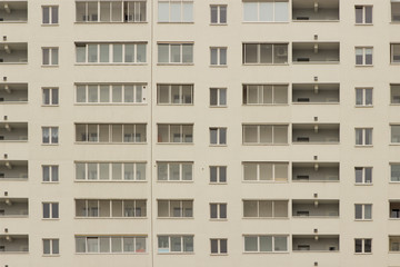 Fototapeta na wymiar facade of a new light, white-gray beige modern high-rise building. Many windows.
