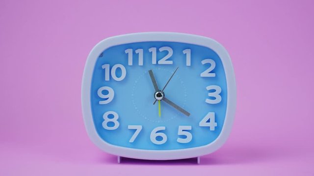  Blue Alarm clock face beginning of time 11.00 am or pm. on pink background.