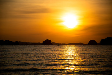 Fototapeta na wymiar Beautiful sunset on the beach with islands