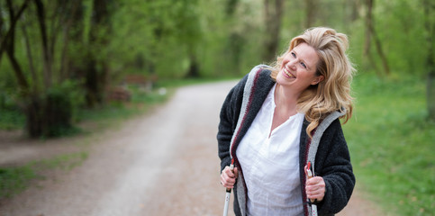Frau im mittleren Alter beim Walken in der Natur 