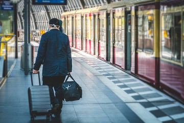 Person with luggage from behind at main train station (Hauptbahnf) in Berlin