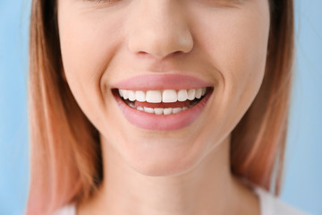 Obraz premium Young woman with healthy teeth on color background, closeup