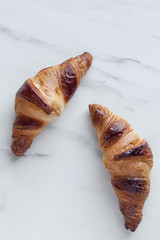 сroissants on a white marble background, top view with copy space