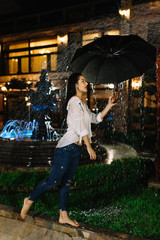 Obraz premium Laughing woman with umbrella checking for rain