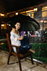beautiful woman with the umbrella sitting on the bench