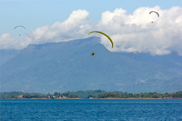 Parachute Flying over Water surface With Background Mountains Trees And Mist On a clear day in Laos. at Nam Ngum Dam Laos