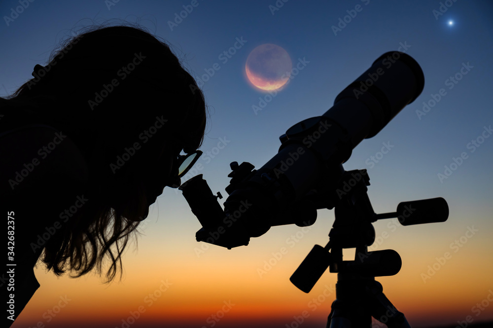 Wall mural silhouette of a woman and telescope with twilight sky.