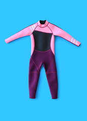Swimsuit for kids, pink and purple with black inserts isolated over cyan background. Fashion sports...