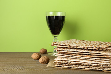 Passover matzos, glass of wine and walnuts on wooden table. Pesach celebration
