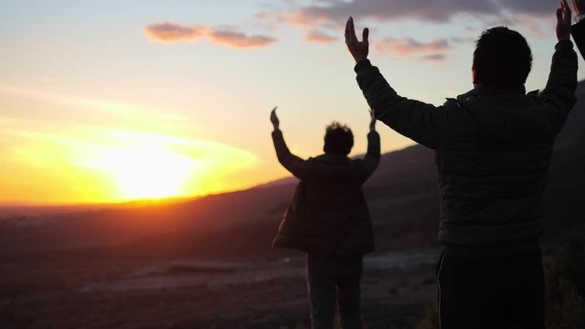 Covid-19, Christians raising hands to pray to God, beautiful sunset on mountain