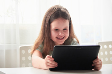 a girl with a tablet computer. Online lessons in self-isolation