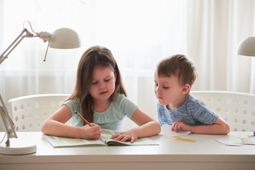 Two small children do their homework at home.