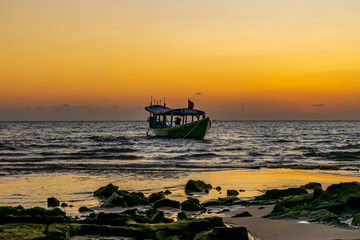 Obraz premium A boat in the sea with the sunset background at Koh Ta Kiev, Cambodia