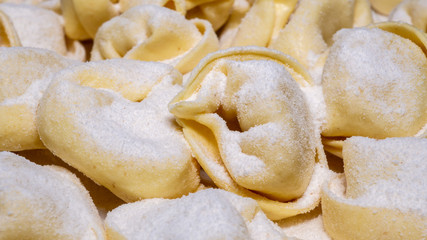 Fototapeta na wymiar Delicious tortellini a ring-shaped pasta from Italy. Traditionally they are stuffed with a mix of meat, parmigiano reggiano cheese, egg and nutmeg