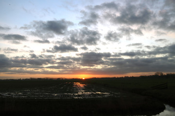 Sunrise over a meadow in Waddinxveen full of water by lots of rain in the Netherlands