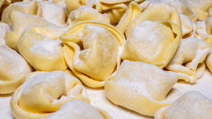 Fototapeta na wymiar Delicious tortellini a ring-shaped pasta from Italy. Traditionally they are stuffed with a mix of meat, parmigiano reggiano cheese, egg and nutmeg
