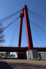 Steel bridge in red color called Willemsbrug in the center of Rotterdam over the Nieuwe Maas river in the Netherlands