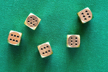 Casino jackpot on the golden dice thrown on the green poker table. Gambling background