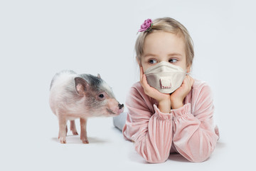 Child girl in medical face mask and pig on white background