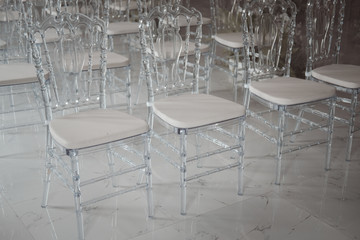 Transparent plastic chairs for wedding guests in a row