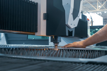 Man controls laser cutting of metal