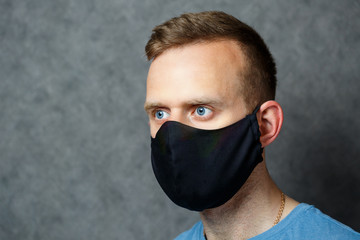 young guy man in black protective medical mask against viruses. COVID 19