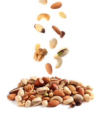 Different nuts falling into pile on white background