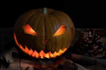 Fototapeta premium Scary and spooky hand carved Halloween pumpkin with flames inside