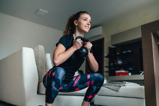 giovane bella ragazza fa sport a casa eseguendo esercizi a corpo libero. Smart gym e distanza sociale durante la pandemia 