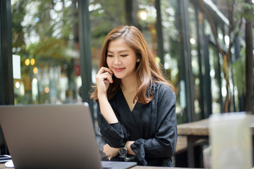 Smart Asian female is working with laptop computer