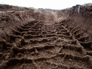 A tire tread mark on the ground. The concept of adventure and discovery, off-road driving. Selective focus.    