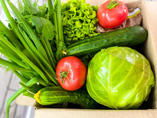 Large box with food, fresh vegetables and herbs.