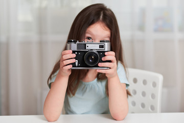Naklejka premium A little girl with an old camera