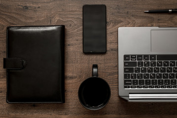 workplace composition with laptop, smartphone, notepad, coffee and pen