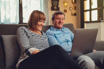 Coppia di europei di mezza età realizza una video chiamata con la famiglia. Tablet, laptop, smartphone. Distanza sociale e tecnologia 